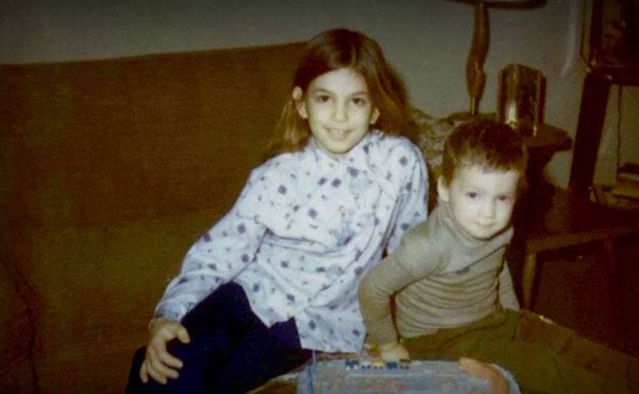 A photo of little Cindy sitting on the couch with her little brother. 