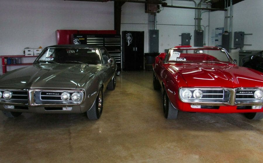 Two fully restored Pontiac Firebirds in the garage. 