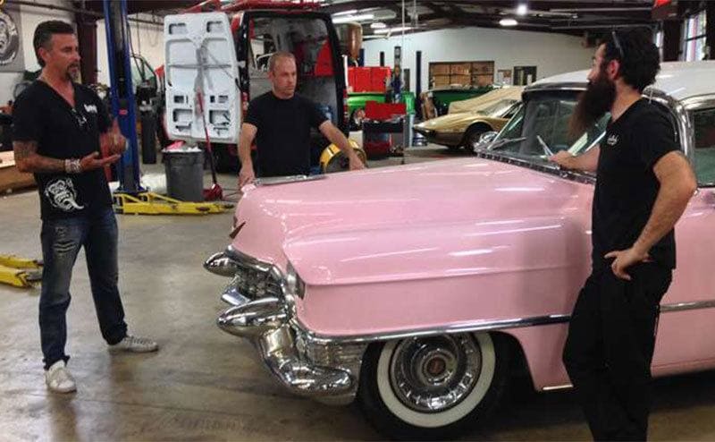 Kaufman, Rawlings, and another “Monkey” are working on a pink vintage car. 
