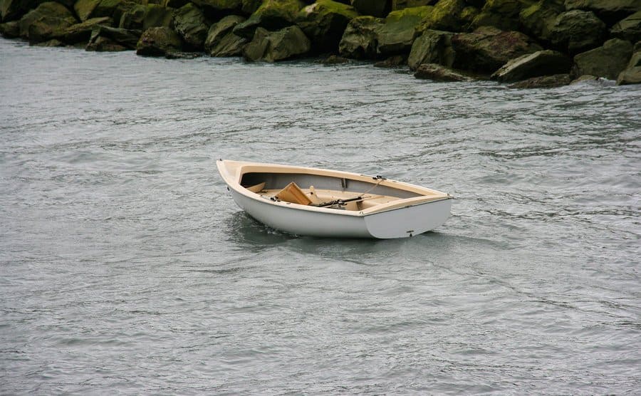 A runaway lonely boat with no ores and no captain drifting in a lake. 