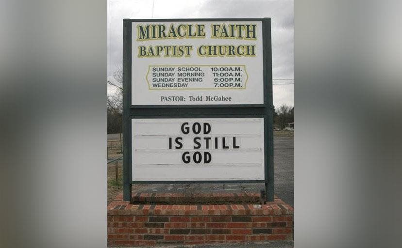 The sign outside the Miracle Faith Baptist Church says, “God is still God”. 
