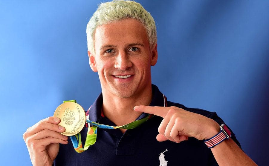 Swimmer, Ryan Lochte of the United States, poses for a photo with his gold medal on the Today show set.
