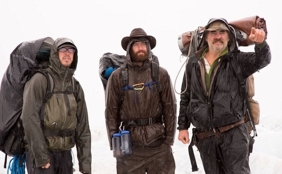 Three men are standing in the freezing weather of Alaska.