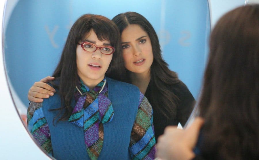 America Ferrera and Salma Hayek are looking at their reflection in the mirror. 