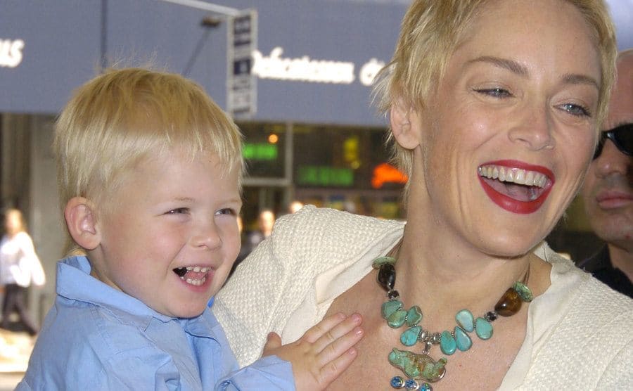 Sharon Stone is holding her baby toddler, Roan, as they attend an event. 