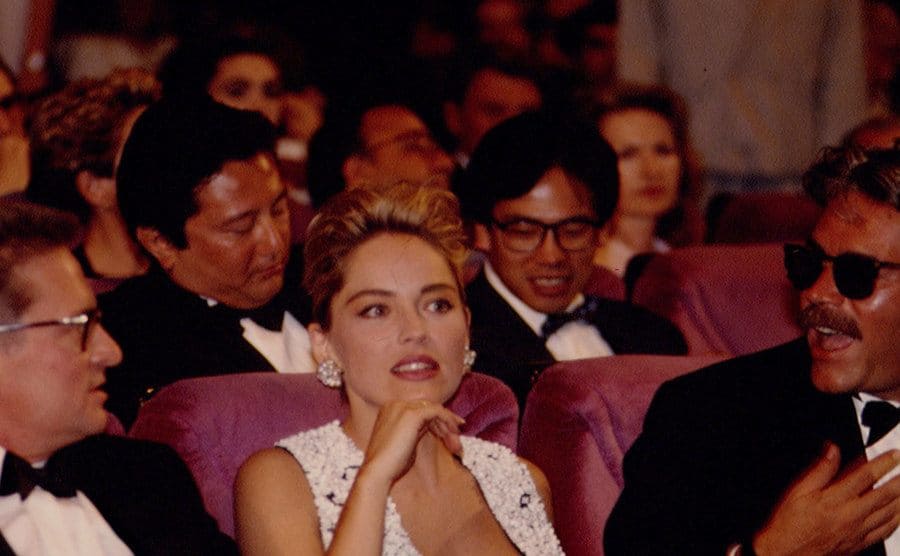 Michael Douglas, Sharon Stone, and Verhoeven are sitting in the front row of a theater. 