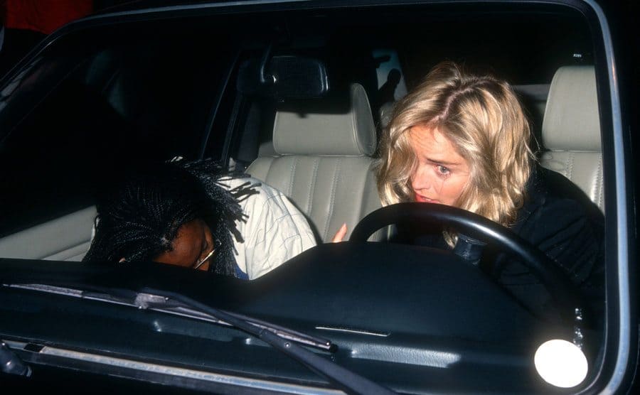 Sharon Stone drives in a car accompanied by her bodyguard.