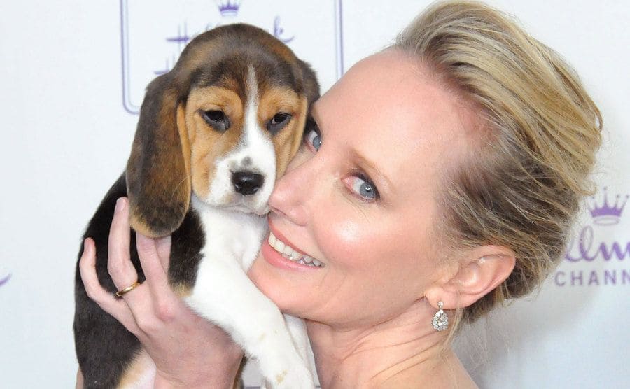 Anne Heche poses as she holds a puppy. 