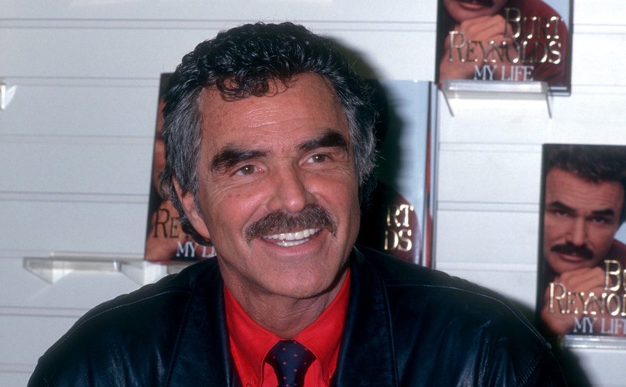 Burt Reynolds smiles at his book signing event. 