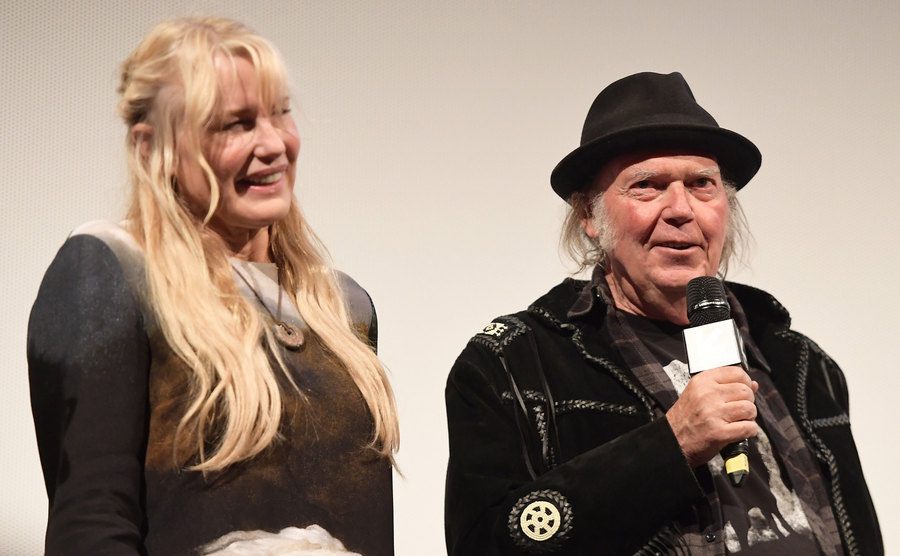 Daryl Hannah and Neil Young speak on stage.