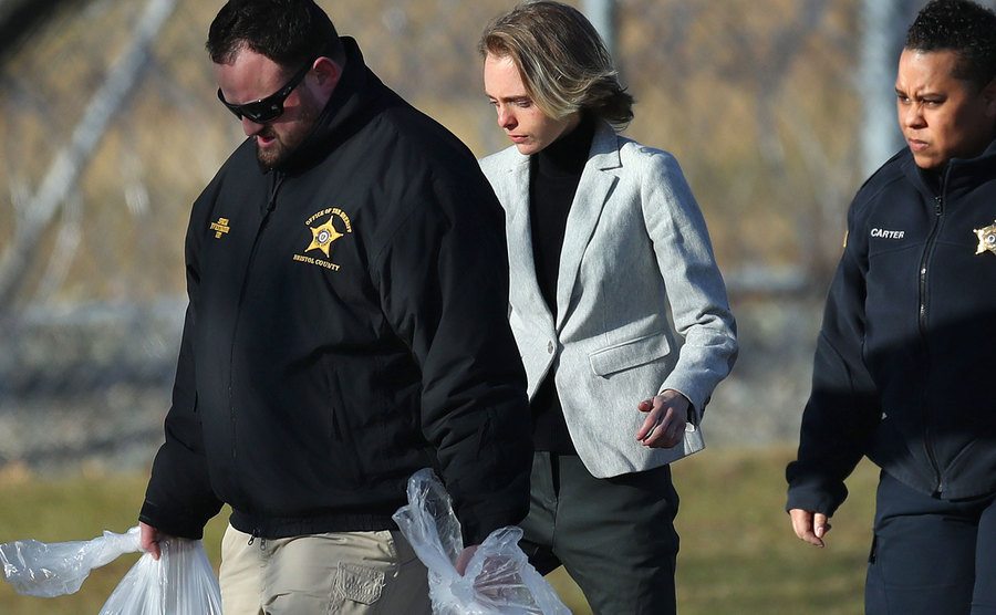 Carter walks out of jail with officers carrying her belongings.