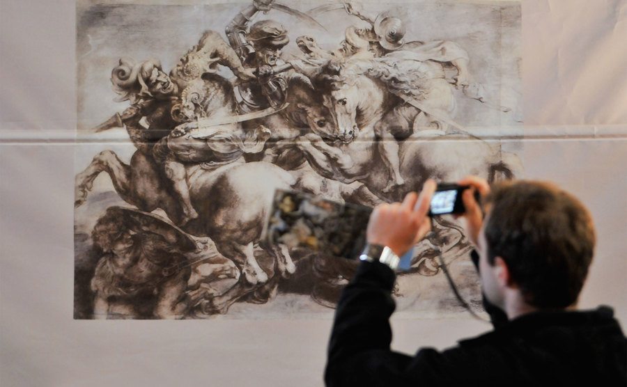A tourist takes a photo of the reproduction of Leonardo's masterpiece The Battle of Anghiari. 