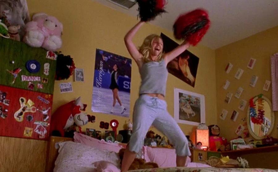 Dunst dances in her bedroom with her pom-poms in a still from Bring It On.