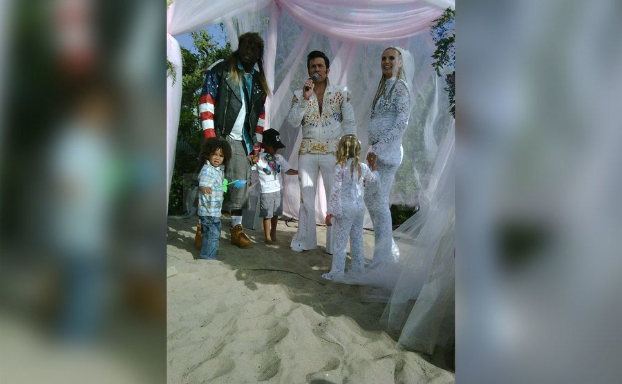 Heidi and Seal stand before an Elvis impersonator officiant for their wedding renewal. 