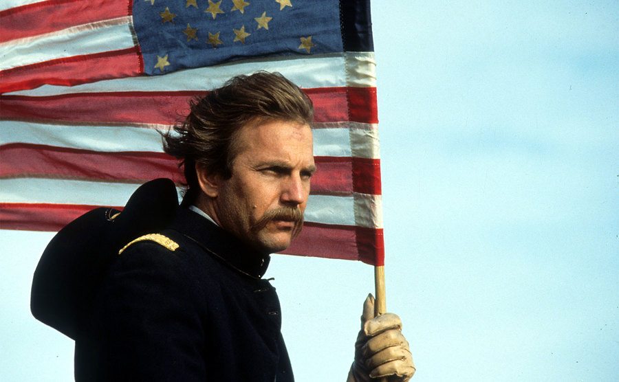 Kevin Costner holding an American flag in a scene from the film 'Dances With Wolves'. 