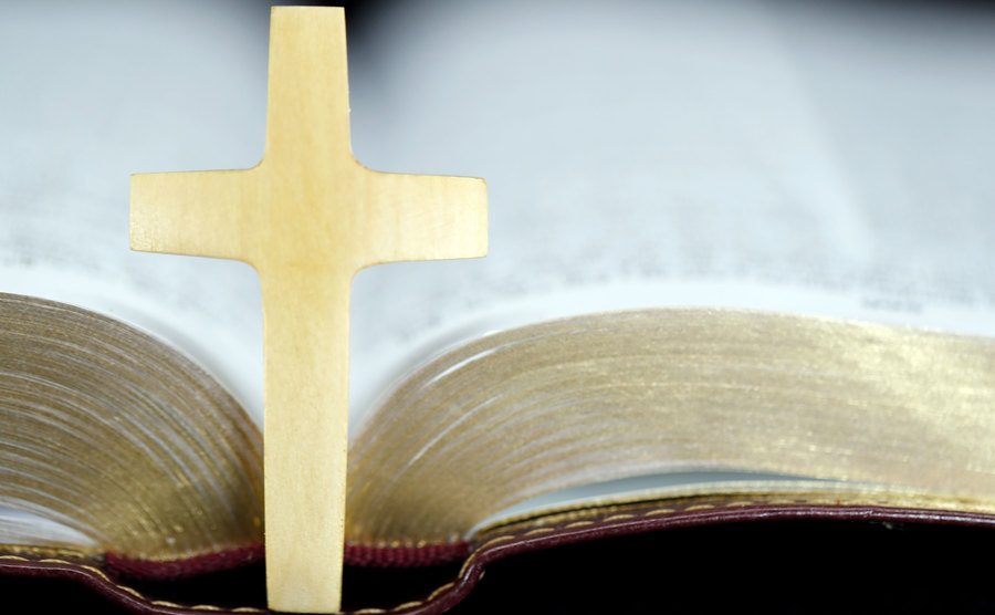 A photo of an open bible with a Christian cross.
