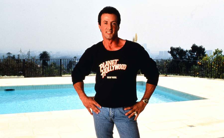 Sylvester Stallone poses beside the pool in his home.