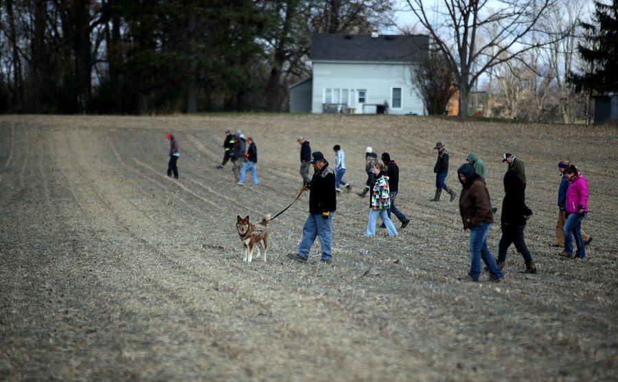 People search a field near the highway looking for Jayme.
