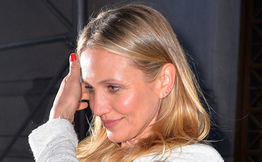 Cameron Diaz tries to cover her face from the media.