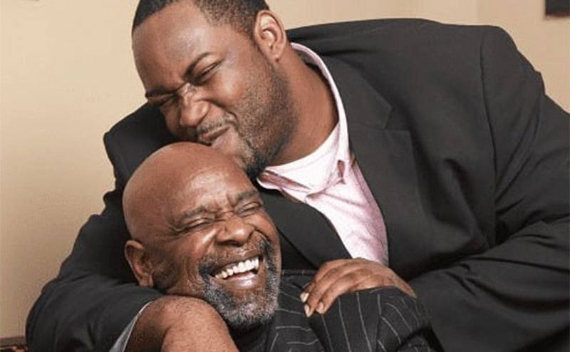 Chris Gardner Jr. kisses his father on the head.