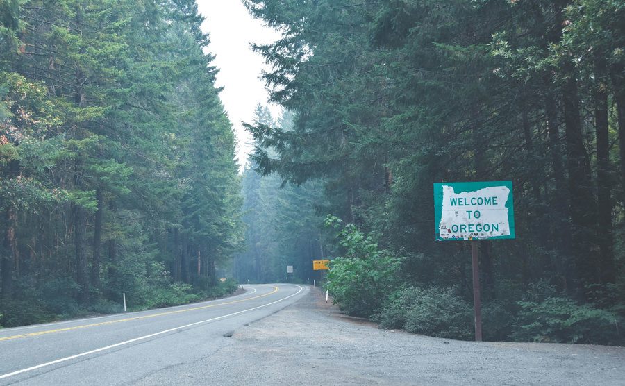 An image of a welcome sign in Oregon’s forest road.