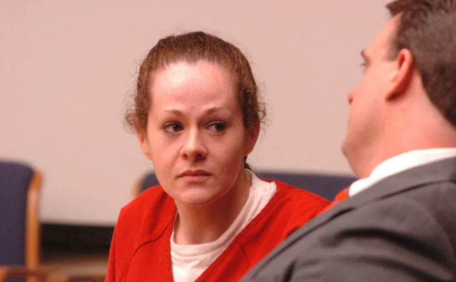 A photo of Christa looking at her lawyer in court.
