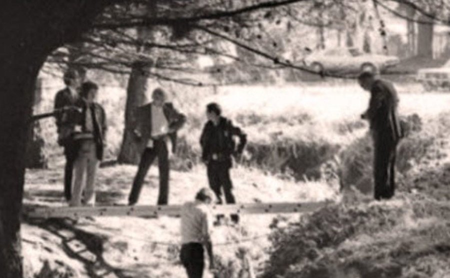 A photo of police officers and detectives investigating a crime scene.