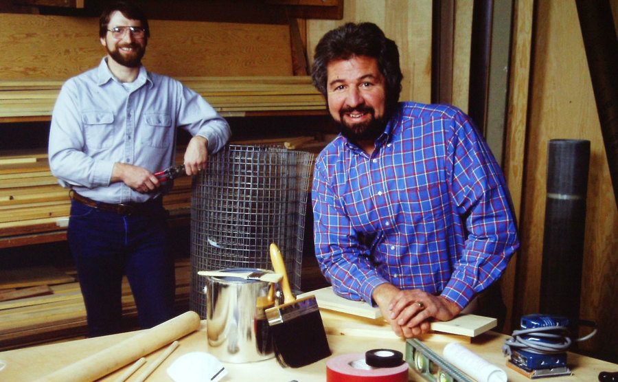 Norm Abram and Bob Vila stand in a workshop. 