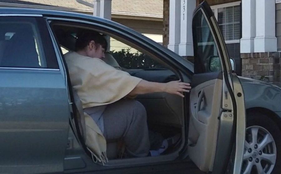 A photo of Cathy getting inside a car.
