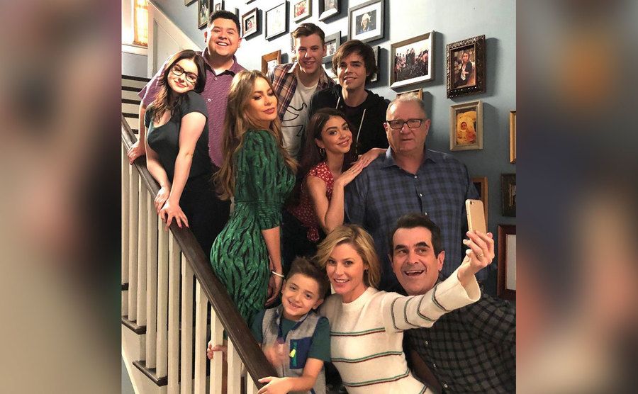 The cast of modern family takes a selfie on set. 