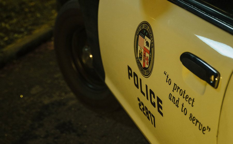An image of a police car parked outside the house at night.