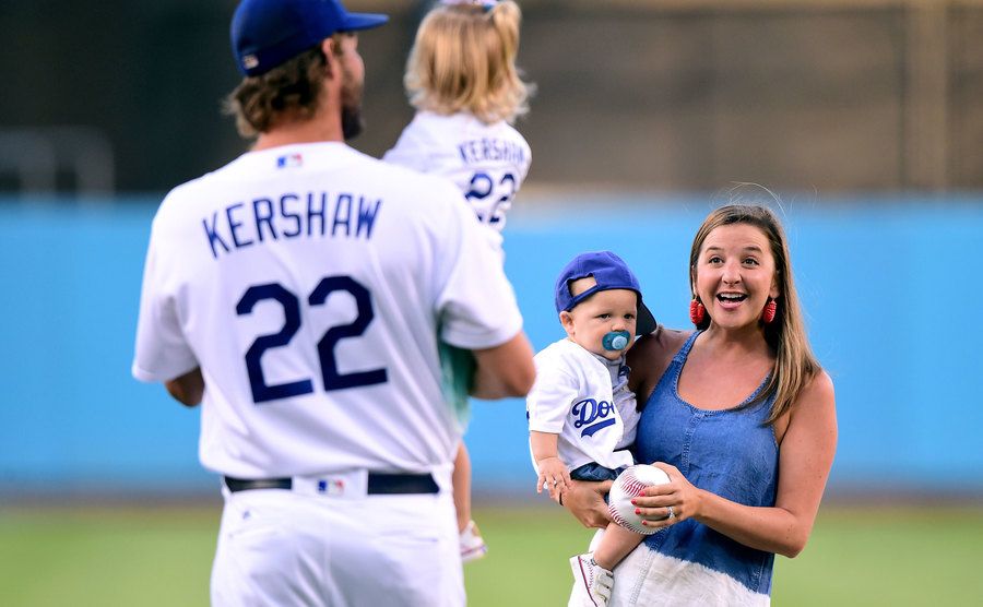 Ellen Kershaw with Charley Kershaw, smile at Clayton Kershaw as he holds his daughter Cali Ann Kershaw. 