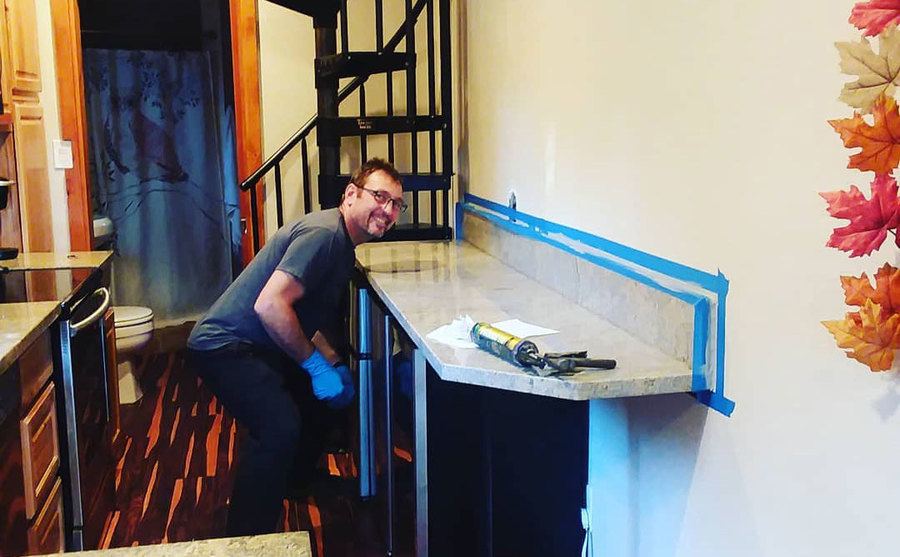 A photo of Dave working on the kitchen of the tiny home.