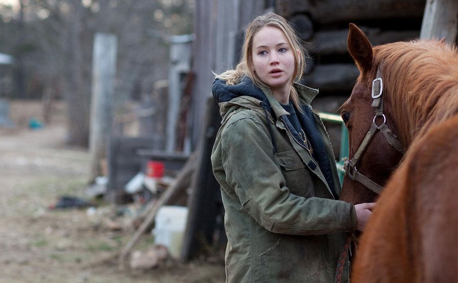 Jennifer Lawrence as Ree Dolly tends to her horse. 