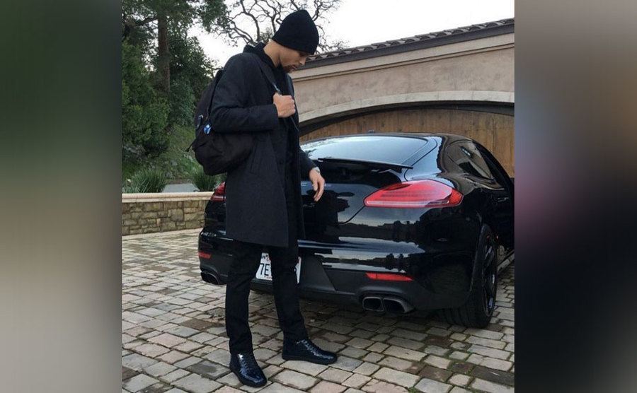 Stephen Curry stands behind his Porsche Panamera