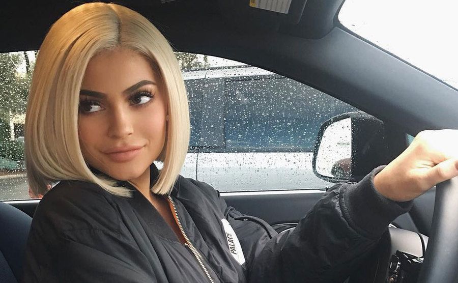 Kylie is in the driver’s seat in the car. 