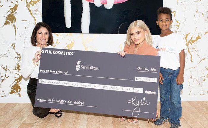 Kylie donates a large check. 