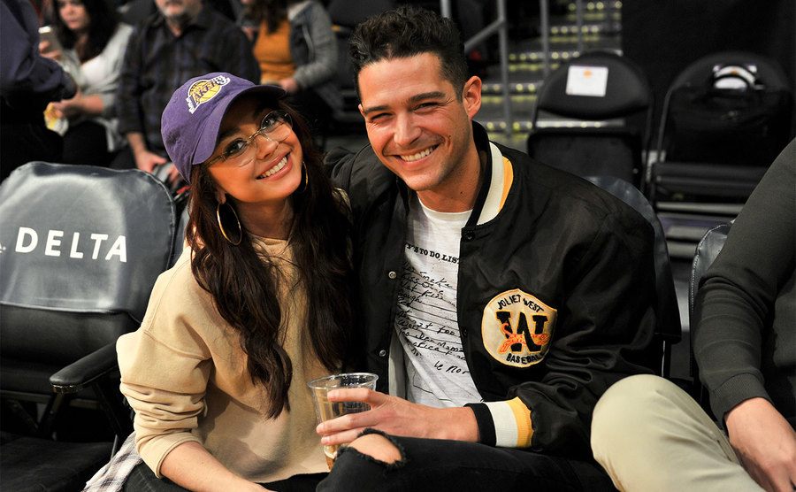 Sarah Hyland and Wells Adams attend a basketball game