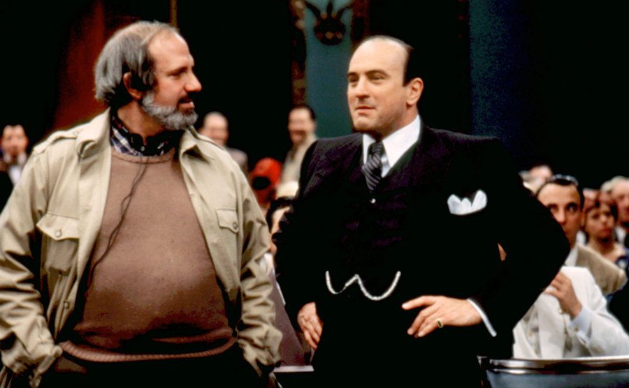 A backstage photo of De Palma and De Niro on set.