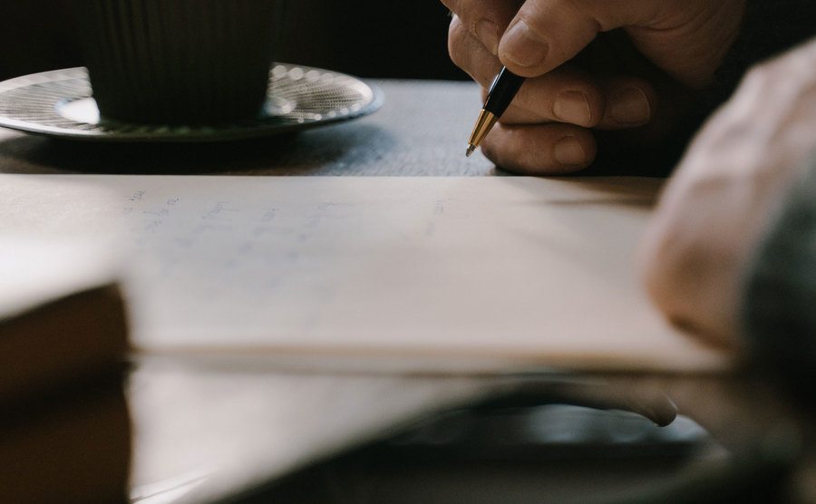 An image of a man writing notes on his desk.