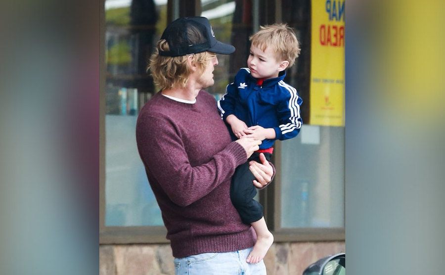 Owen Wilson holds his son in his arms. 