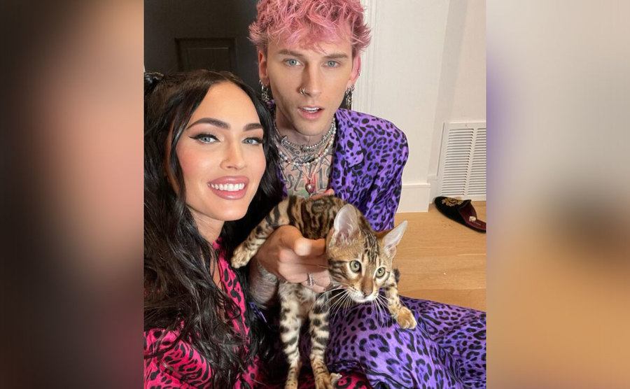 Megan and MGK are wearing cat print pajamas to match their cat. 