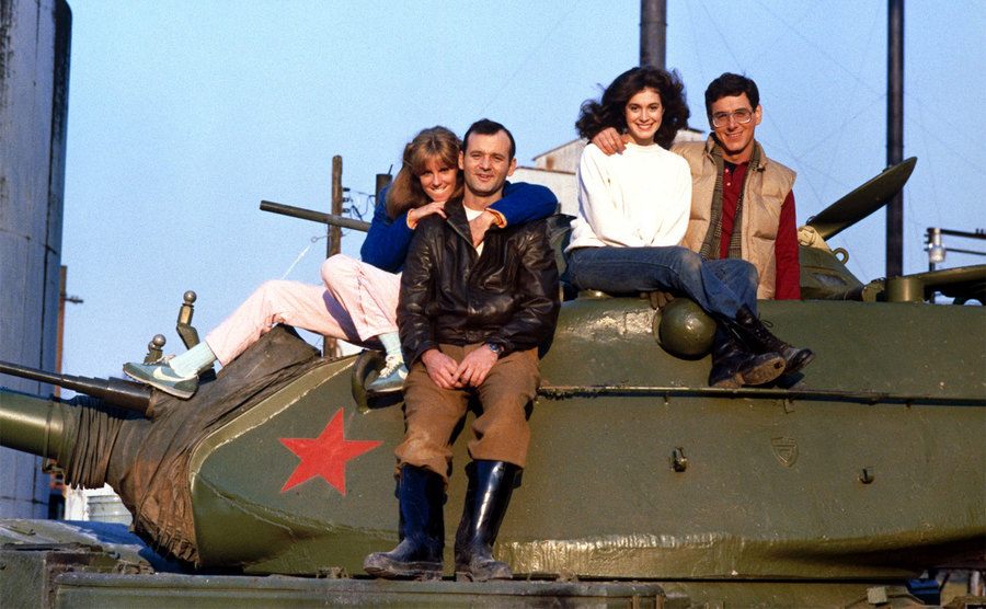 The cast of Stripes poses on top of a tank. 
