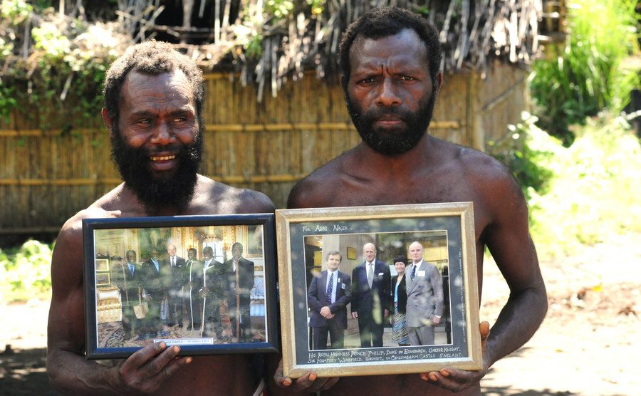 An image of worshipers holding pictures of Prince Philip.