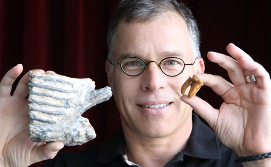 Dr. Zuk holds up a mammoth molar and a tooth from his collection.