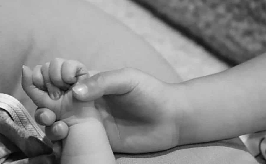 An image of Kylie holding her newborn hand.