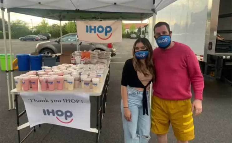 Sadler poses for a photo with the hostess from IHOP at a charity event. 
