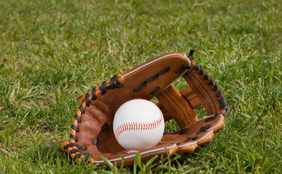 An image of a baseball glove in the grass.