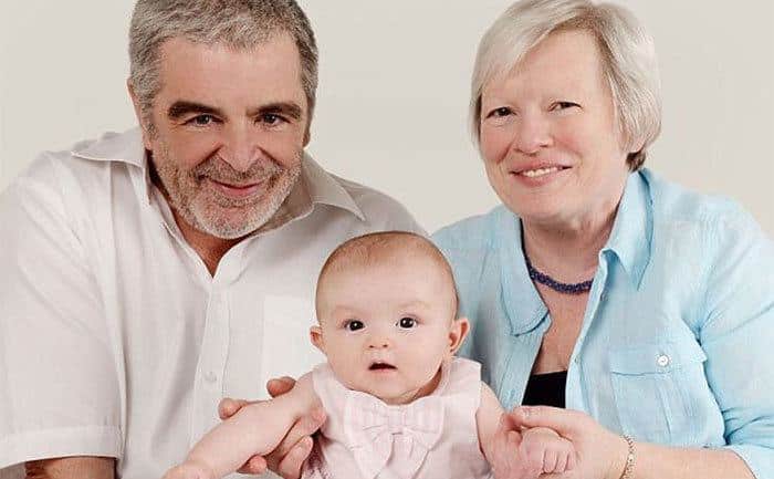 Les and Joy pose with their grandchild. 