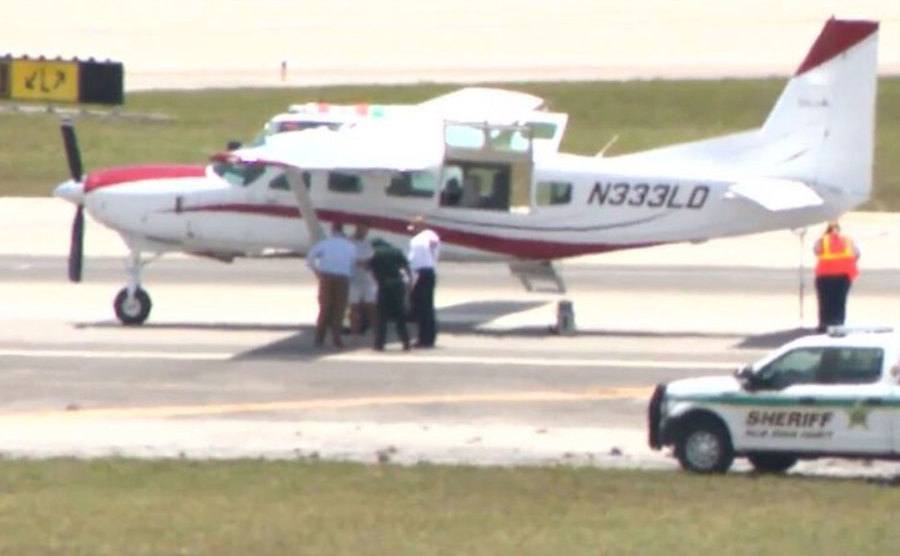 An image of officers standing by the plane after landing.